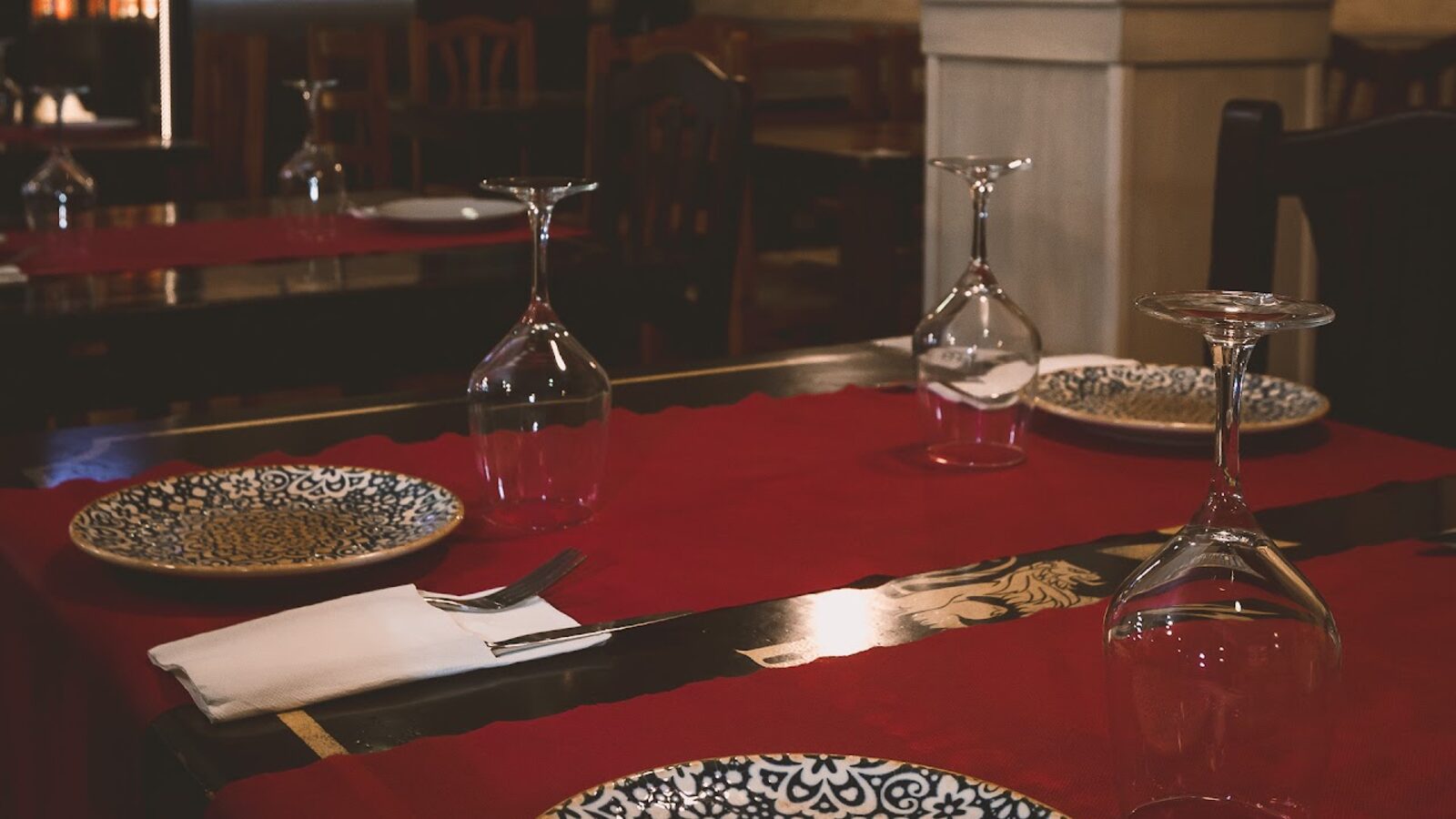 Mesa puesta con mantel rojo en el comedor de Pizzería Tellaro